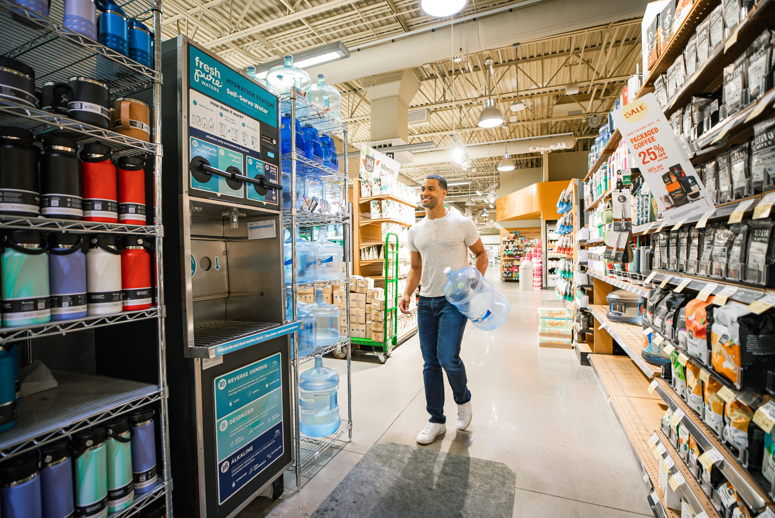 man walking up to a freshpure water refill staion in whole foods