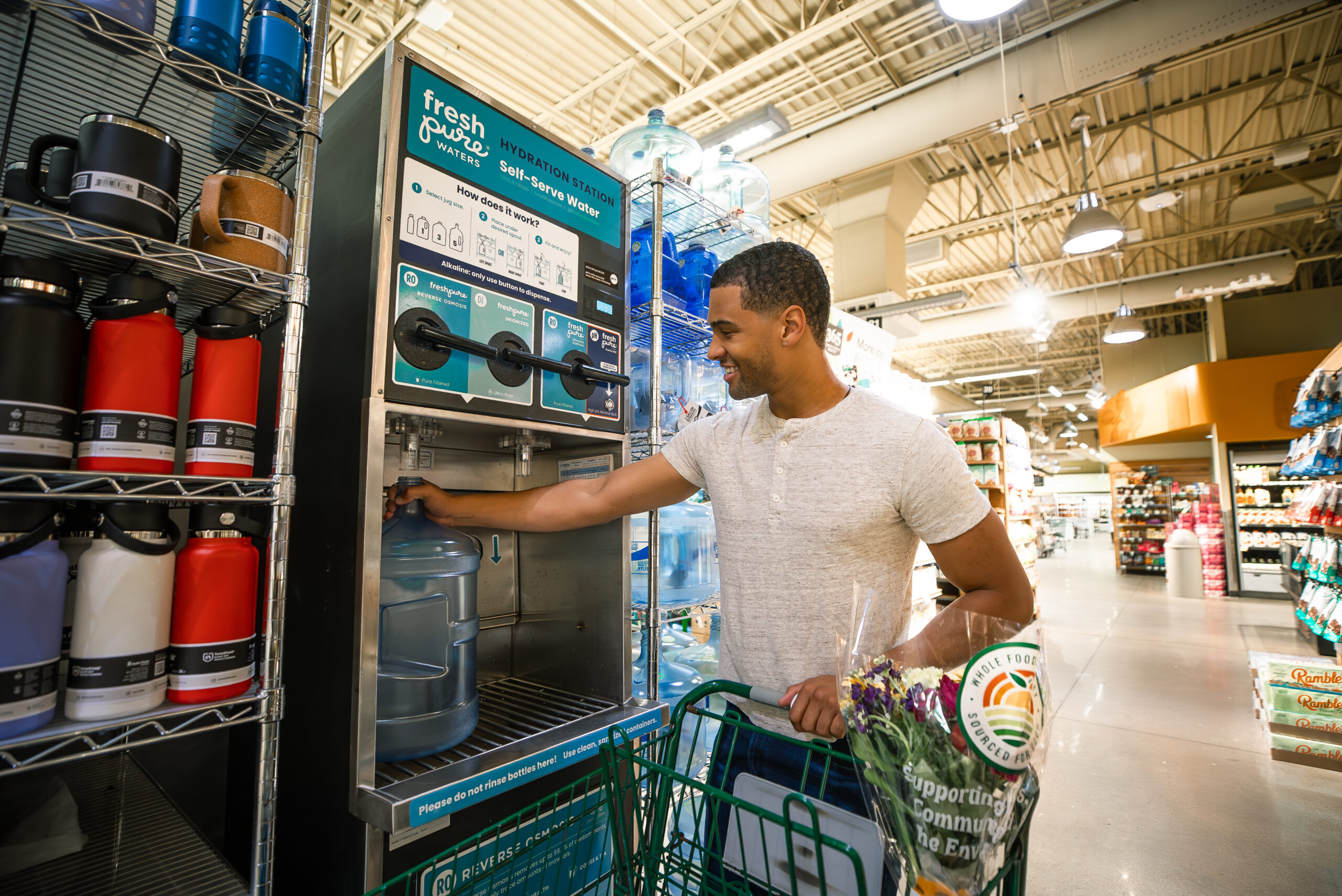 man lining up his 5 gallon water bottle under the reverse osmosis water spout